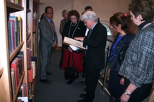 M. Moojan Momen montrant un manuscrit rare en langue persane aux invités réunis à l’ouverture officielle de la Afnan Library, à Sandy au Royaume-Uni, le 12 février 2015.