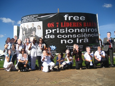 Au Brésil, les militants des droits de l’homme portent des masques représentant les sept responsables bahá’ís iraniens emprisonnés devant le Congrès national brésilien à Brasilia.