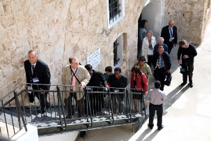 Les délégués de la Convention Internationale  se préparent spirituellement aux élections en visitant les lieux saints bahá’ís situés dans le secteur de Haïfa- St Jean d’Acre et Bahji. Ici, on les voit montant les escaliers qui mènent à la cellule dans laquelle Baha’u’llah a été incarcéré dans la ville fortifiée de Saint Jean d’Acre.