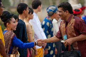Les hôtes en costumes traditionnels des pays participants - le Cambodge, le Laos, la Thaïlande et le Vietnam - accueillent les participants arrivant à la conférence bahá'íe de Battambang.