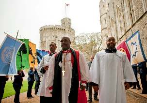 L’ensemble est encadré par le drapeau des Nations unies, à gauche et par un certain nombre de symboles religieux, y compris bahá’í, à droite.