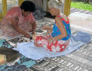 Les artistes de tapa, Bale Jione et Robin White, travaillent sur des dessins complexes réalisés sur le tissu d’écorce. La troisième artiste, Leba Toki, était ici en dehors du champ de la photo. (Photos de courtoisie de Robin White)