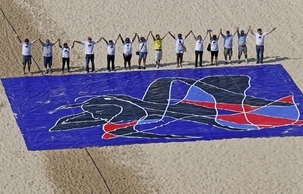 À Rio de Janeiro, au Brésil, les participants à la campagne « Cinq années de trop » se sont alignés sur la plage de Copacabana le dimanche 5 mai, derrière une fresque créée par l’artiste brésilien renommé, Siron Franco.