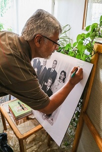 Issa Saharkhiz, un important journaliste iranien, signant une photo des sept anciens responsables bahá’ís en Iran.