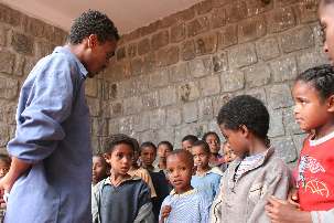 L’enseignant met les enfants en rang afin qu’ils puissent répéter une chanson, qui sera présentée lors du concert