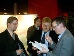 Elmar Brok (centre) député allemand au Parlement européen entouré de Peter Amsler, représentant bahá'í et d'un autre participant au vernissage de l'exposition