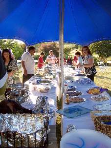 Les amis qui se sont rassemblés à Eureka dans la région de Waikato en Nouvelle-Zélande préparent la table du banquet pour leur célébration de Naw-Rúz