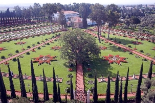 Cette photo montre le site de la commémoration du  9ème Jour saint de Ridván. Les bahá’ís étaient assis sur des chaises, sur la périphérie du cercle que l’on voit ici et faisaient face au Tombeau de Bahá’u’lláh. Le Tombeau est la construction carrée à l’avant garde des autres bâtiments. Le manoir de Bahji, où Bahá’u’lláh y a vécu ses dernières années terrestres, est le grand bâtiment blanc.