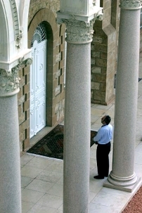 Un participant à la Convention marque une pause à l’entrée du tombeau du Bàb sur le Mont Carmel. Le tombeau abrite les restes terrestres du Bàb, le messager divin qui était le précurseur de Bahá’u’lláh.