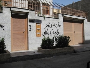 Une maison de Semnan avec des graffitis injurieux tagués qui, traduits en français, disent : « À bas le païen bahá’í. À bas l’Amérique et la Grande-Bretagne.»