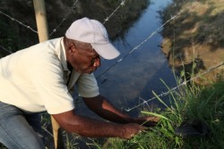 Don Hernan Zapata plante de nouveaux arbres le long d’une clôture entourant le site de la maison d’adoration.