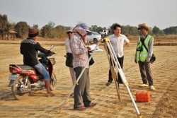 Une équipe faisant des relevés de niveau pour la route conduisant à l’endroit choisi pour la maison d’adoration bahá’íe à Battambang, au Cambodge.
