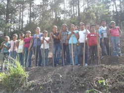 Un groupe d’élèves de cinquième apprenant à préparer des parcelles de verger pour planter des cultures dans le cadre du programme SAT au Honduras