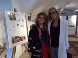 Sussan Zarifzadeh (à gauche) et Eva Gorgosilich, la représentante de l’Église catholique (à droite), devant une exposition préparée pour la célébration du bicentenaire qui a eu lieu la semaine dernière à Bruck. L’exposition présente les enseignements de Bahá’u’lláh ainsi que les enseignements des autres grandes religions du monde et souligne l’impératif de l’unité.