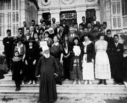 Un groupe de bahá’ís et d’autres personnes en compagnie de ‘Abdu’l-Bahá à l’extérieur de sa maison à Haïfa. Deux soldats indiens se trouvent au dernier rang. (vers 1918).