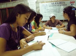 Un petit groupe de jeunes aux Philippines étudie et échange sur la documentation fournie pour le séminaire.