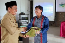 M. Haji Ibnu Hasan Muchtar, chercheur principal du ministère indonésien des Affaires religieuses, recevant un cadeau de la communauté bahá’íe d’Indonésie.