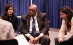 Carl Murrell (au centre) du Bureau bahá’í des affaires publiques des États-Unis à une discussion de groupe lors du Parlement des religions du monde, tenu en novembre à Toronto.