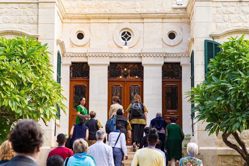 Un groupe de participants s’approche de l’entrée de la maison de ‘Abdu’l-Bahá.