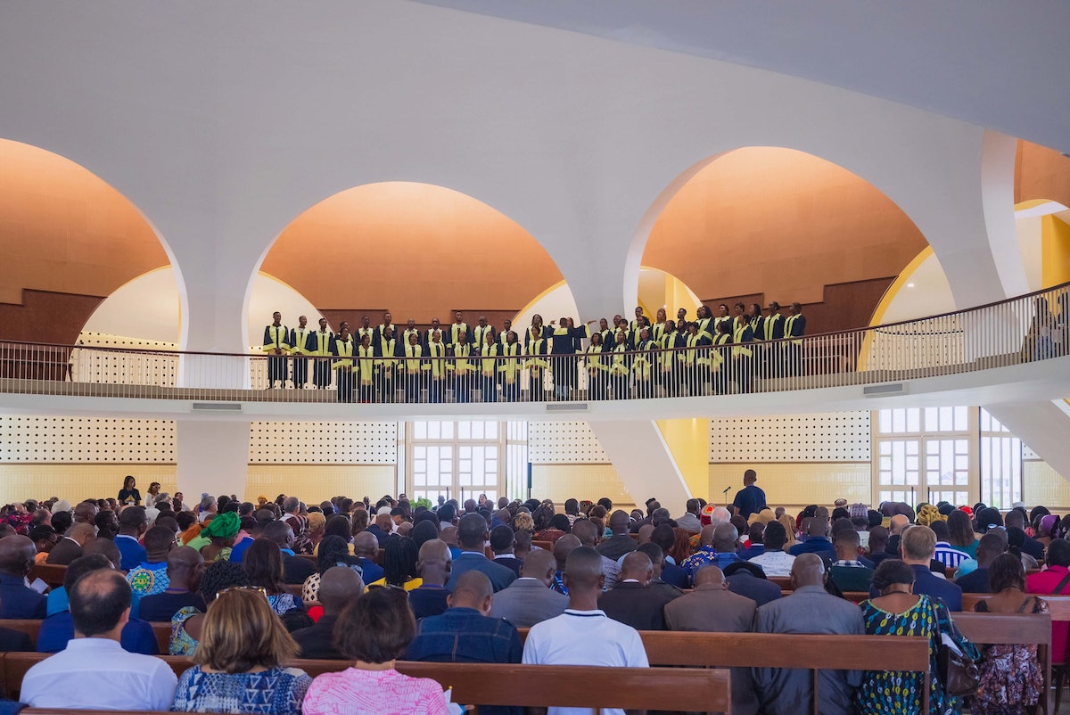 Chorale chantant une prière mise en musique lors du programme de dévotion à l’intérieur de l’édifice central.