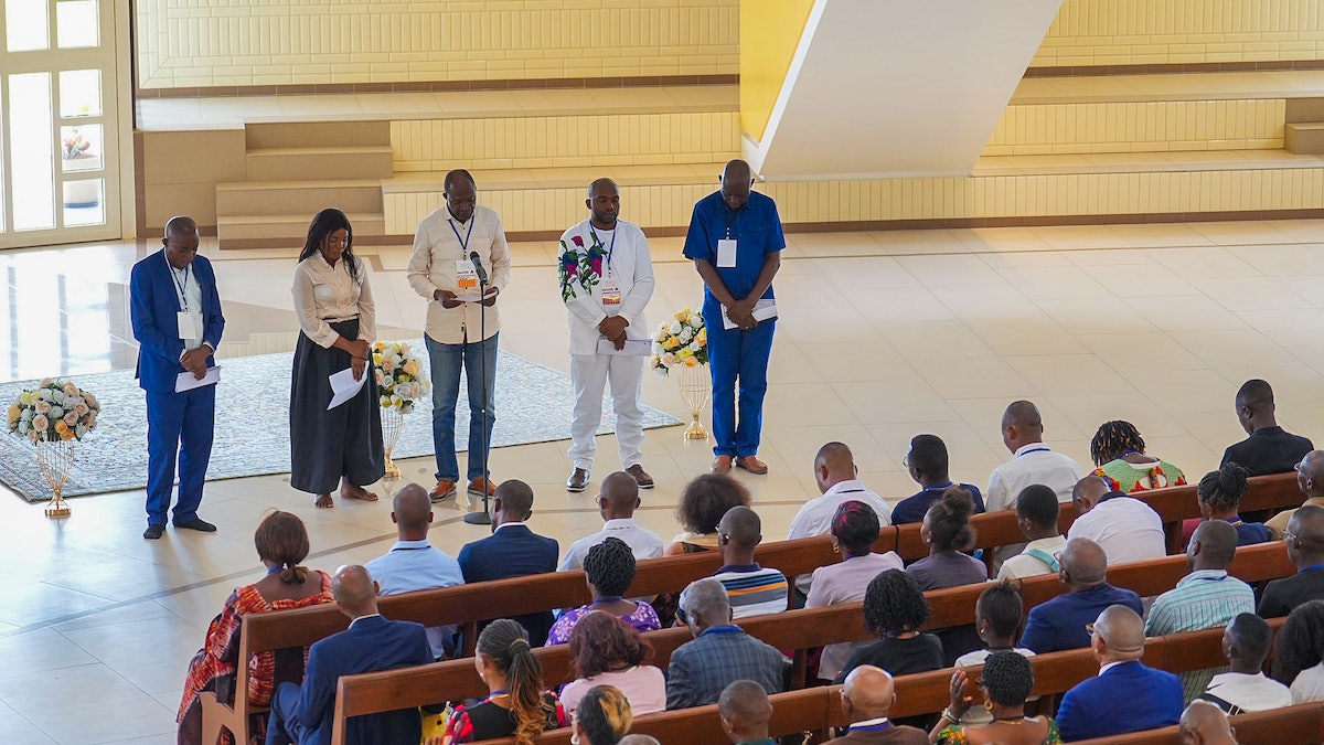 Des participants assis à l’intérieur de la maison d’adoration pour son premier programme de dévotion composé de prières et d’écrits bahá’ís.