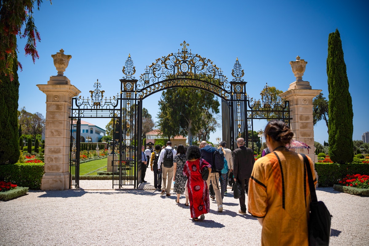 Délégués franchissant la porte Amelia Collins pour se rendre au tombeau de Bahá’u’lláh.