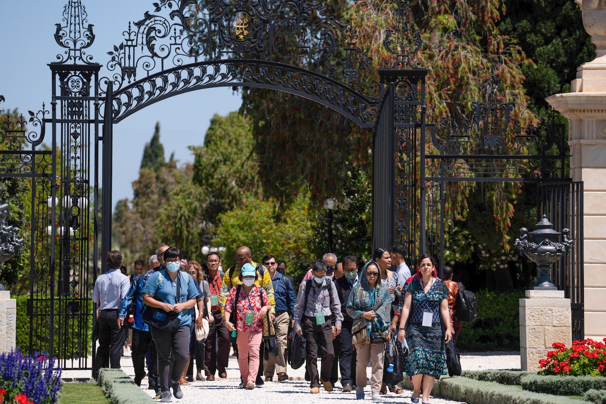 Un groupe de délégués entre par la porte Amelia Collins et s’approche du tombeau de Bahá’u’lláh.