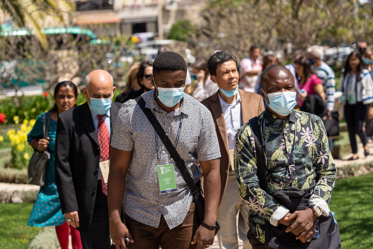 Des participants à la Convention venus de pays tels que l’Inde, le Myanmar, les Philippines et la Sierra Leone s’approchent de l’ancienne maison des pèlerins près de la maison de ‘Abdu’l-Bahá.