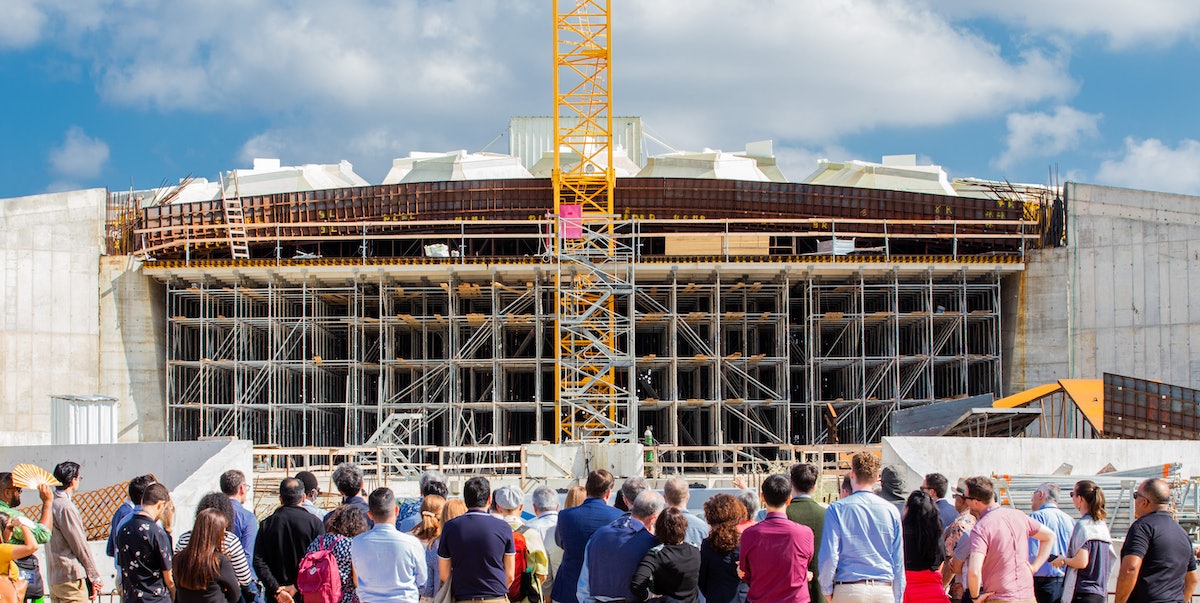 Des représentants et d’autres participants à la Convention se rassemblent devant la place sud du futur mausolée de ‘Abdu’l-Bahá.