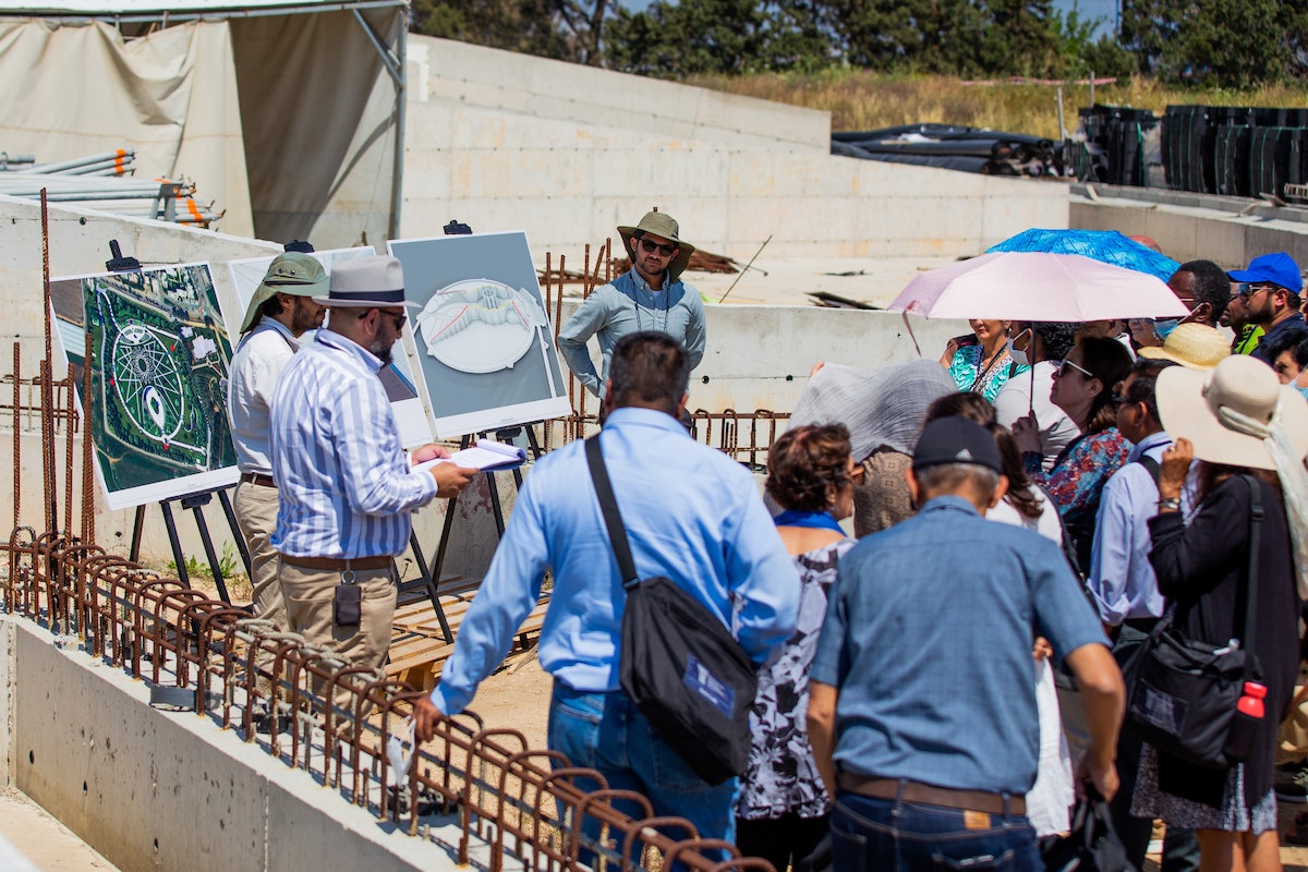 Délégués écoutant une présentation sur la place sud du futur mausolée de ‘Abdu’l-Bahá pendant leur visite.