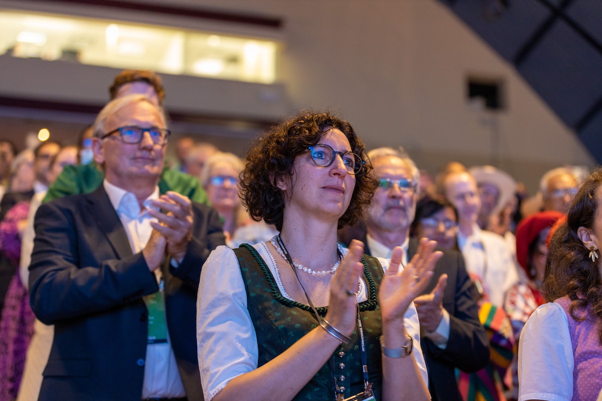 Une déléguée se lève pour applaudir lors de la séance d’ouverture de la 13e Convention internationale bahá’íe.