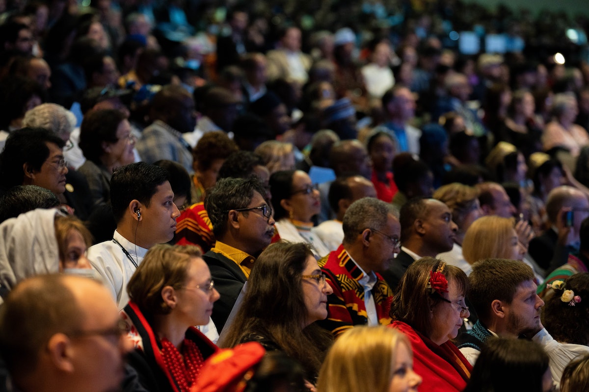 Les participants à la convention écoutent attentivement, beaucoup d’entre eux bénéficiant d’une traduction simultanée pendant qu’un délégué s’exprime.