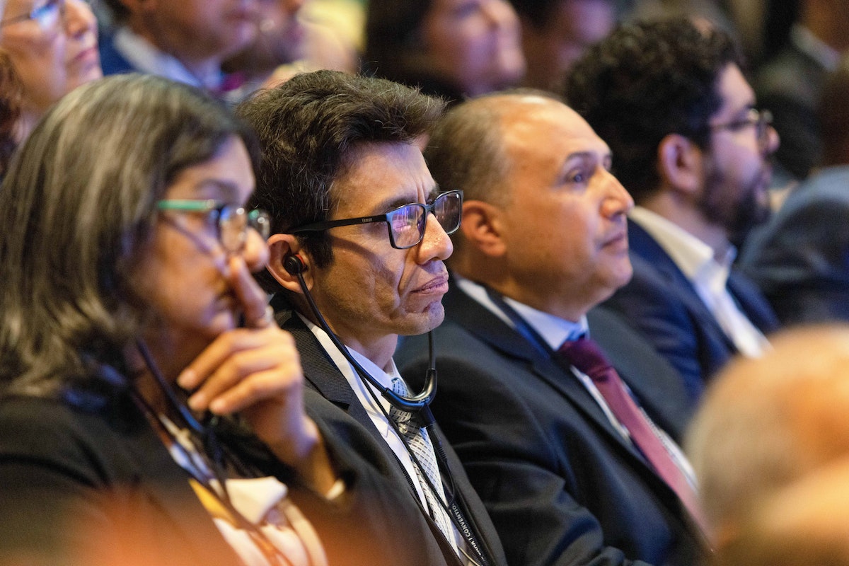 Des délégués du Pérou écoutent des traductions en direct lors d’une session consultative à la 13e Convention internationale bahá’íe.