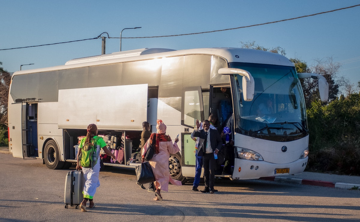 Des participants montent dans un bus pour l’aéroport après la célébration du Jour saint à Bahjí.