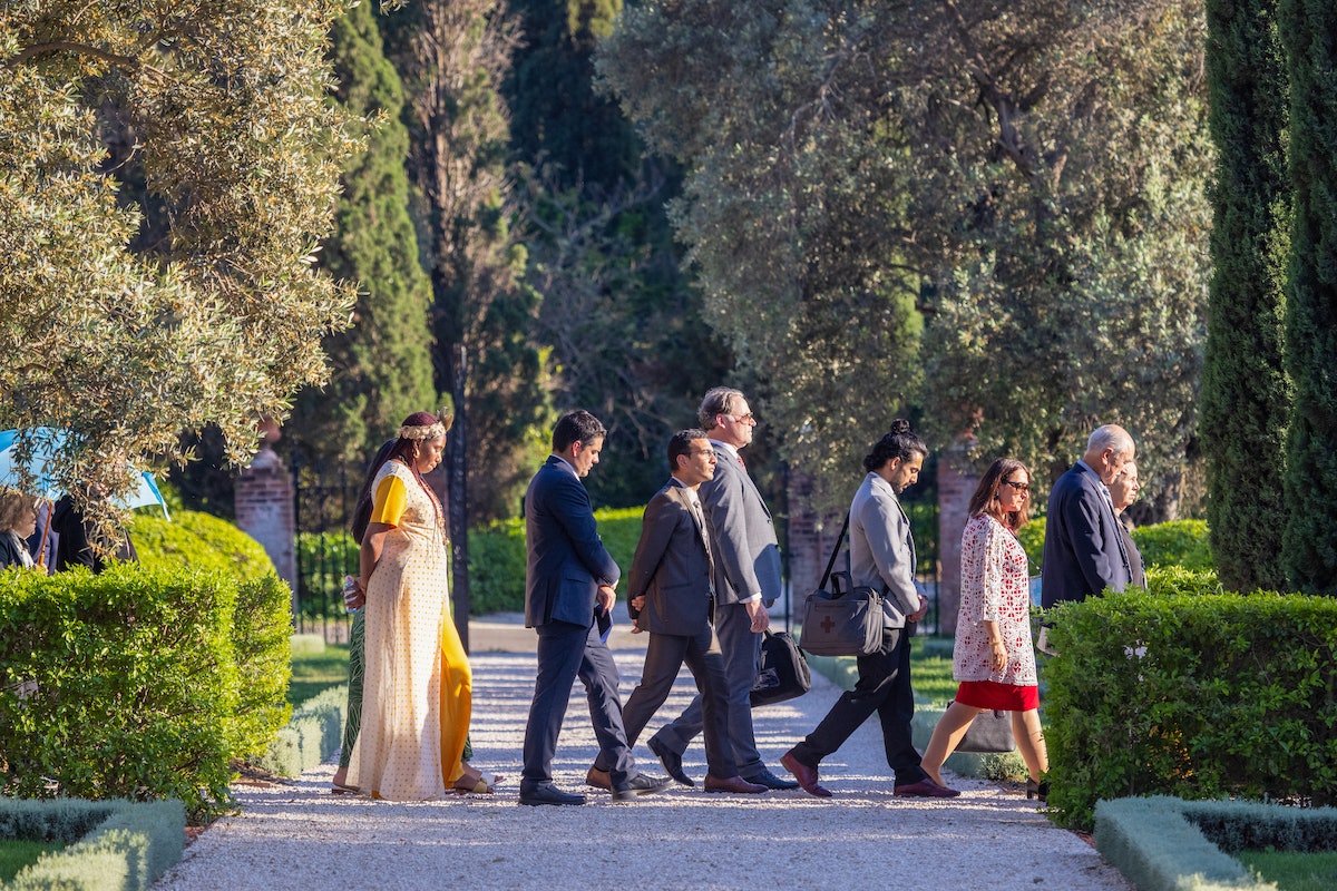 Des participants se promènent dans les jardins entourant le tombeau de Bahá’u’lláh.