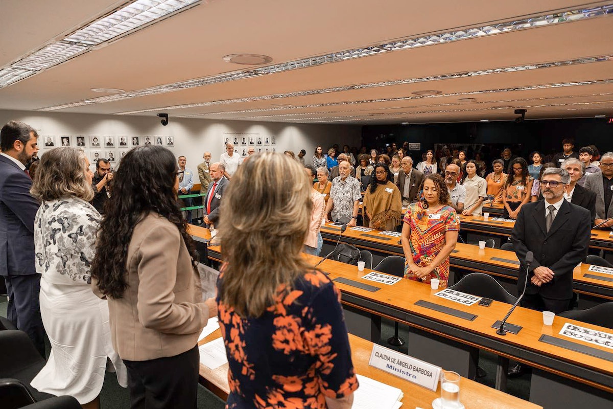 Les participants se lèvent pour une minute de silence demandée par la députée fédérale Erika Kokay de la chambre basse du Congrès.