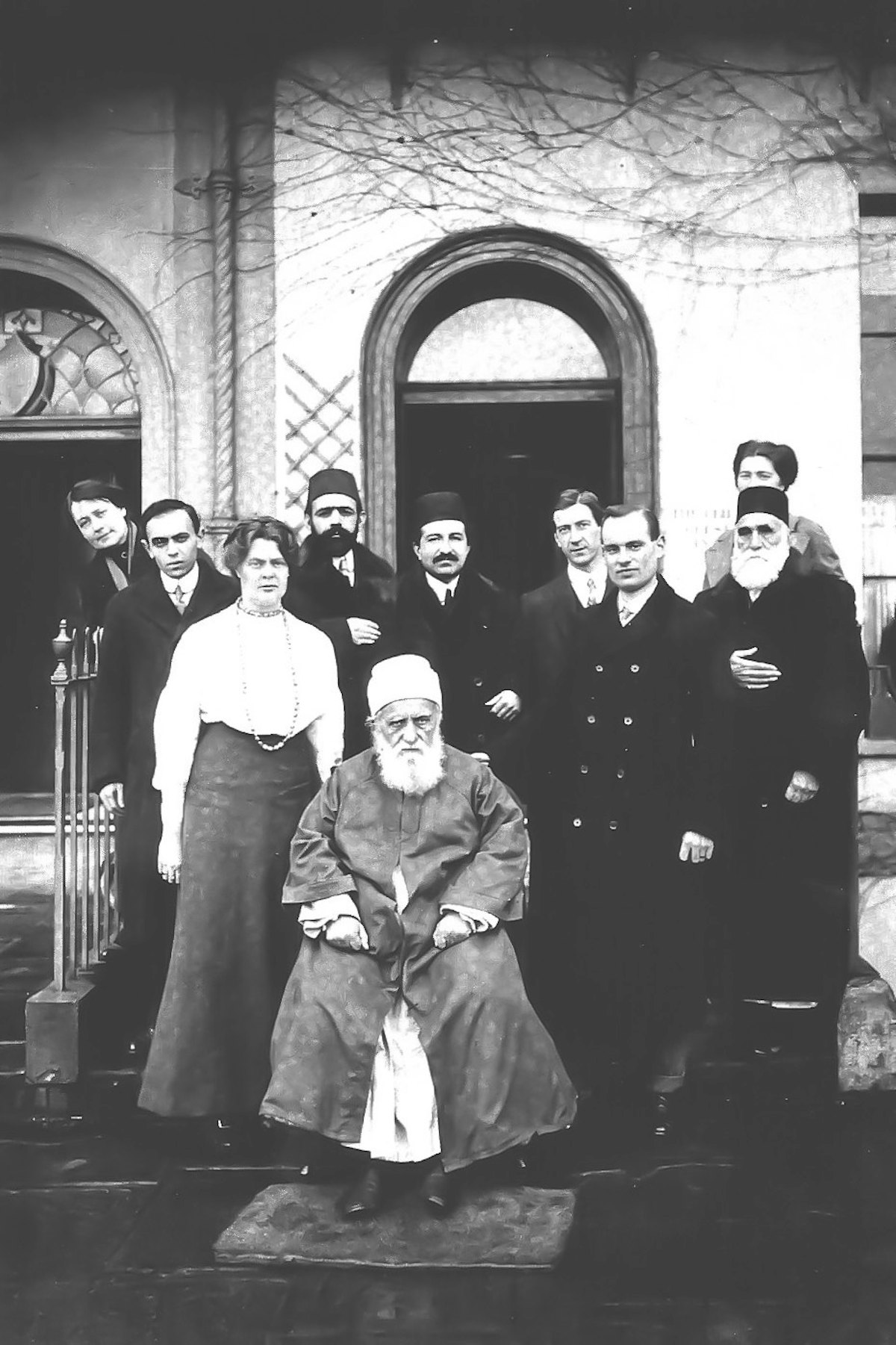 Photo de ‘Abdu’l-Bahá (au centre) en 1913 à l’extérieur du Royal York Crescent à Bristol ; Wellesley Tudor Pole (au centre à droite).